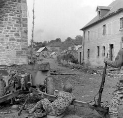 Le Pont Brocard, hameau de Dangy (Manche), deux GI's en tenue camouflée derrière un canon antichar de 57 mm baptisé "BONNIE-I"